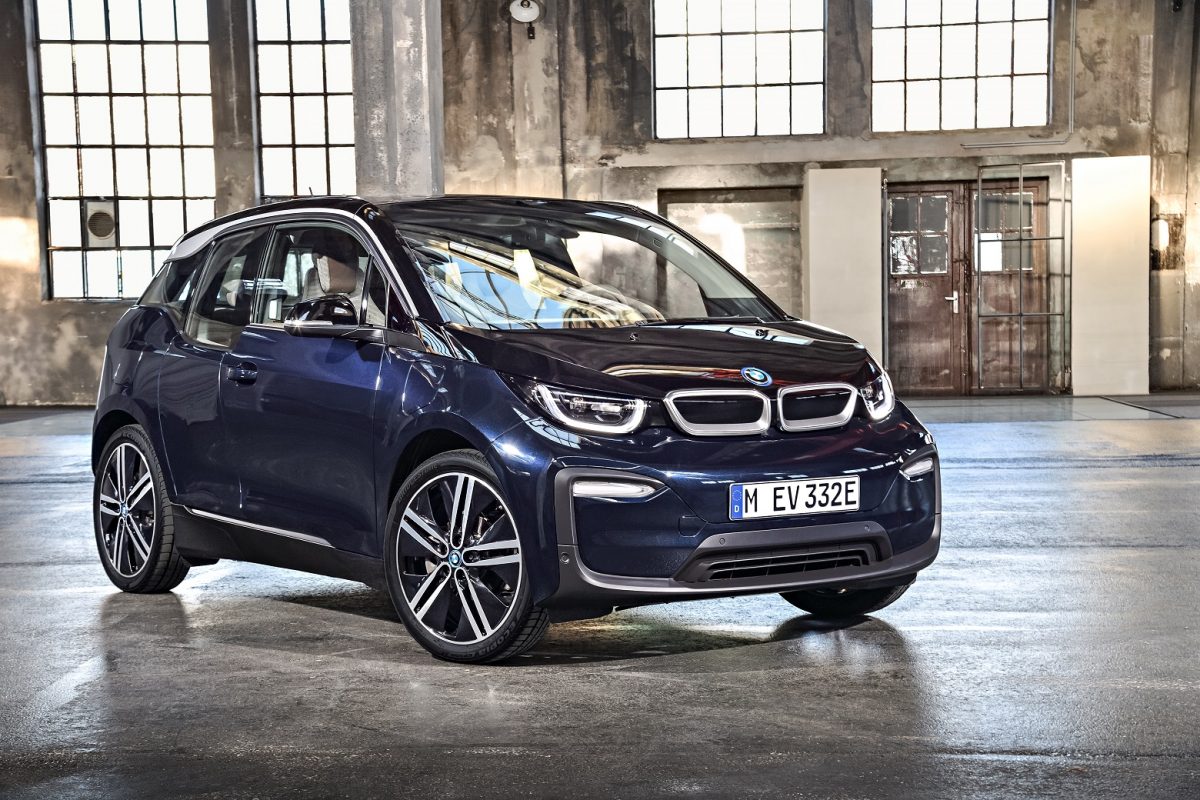 BMW i3 azul parado de frente dentro de um galpão