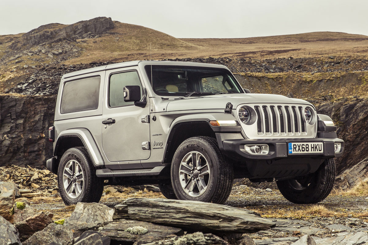 A edição Jeep Wrangler Sahara prata parada de frente com montanha ao fundo