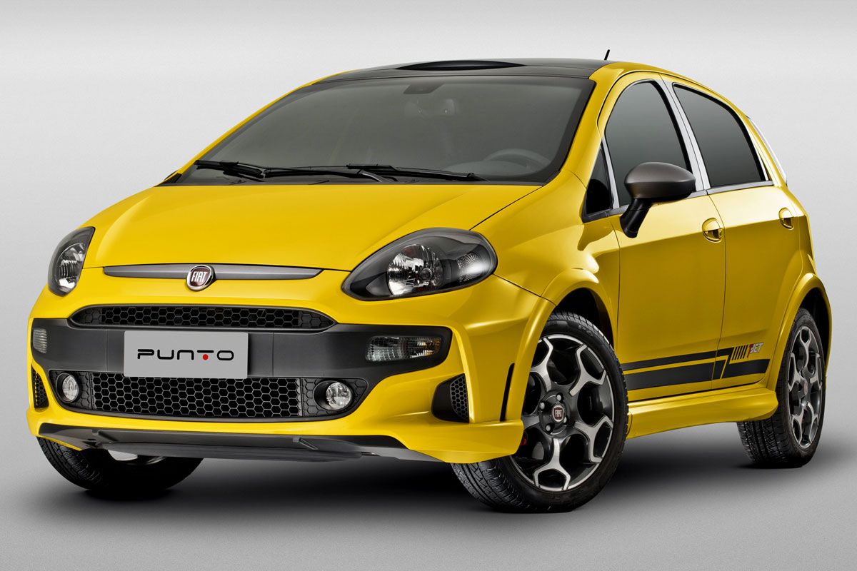 Fiat Punto T-Jet amarelo com motor Fire parado de frente com fundo e chão cinza