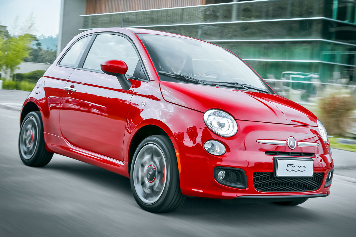 Fiat 500 vermelho andando na cidade com prédio ao fundo era um carro equipado com sistema de som da Bose 