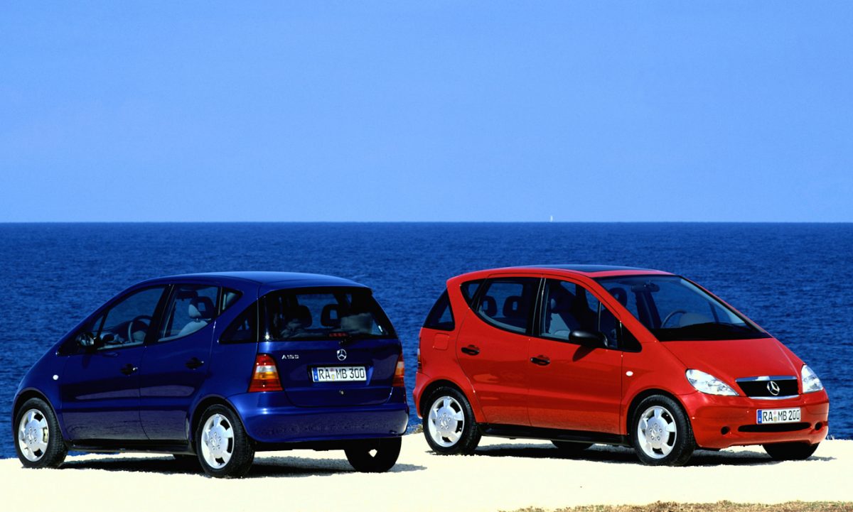Mercedes-Benz Classe A azul e vermelho na praia com mar ao fundo