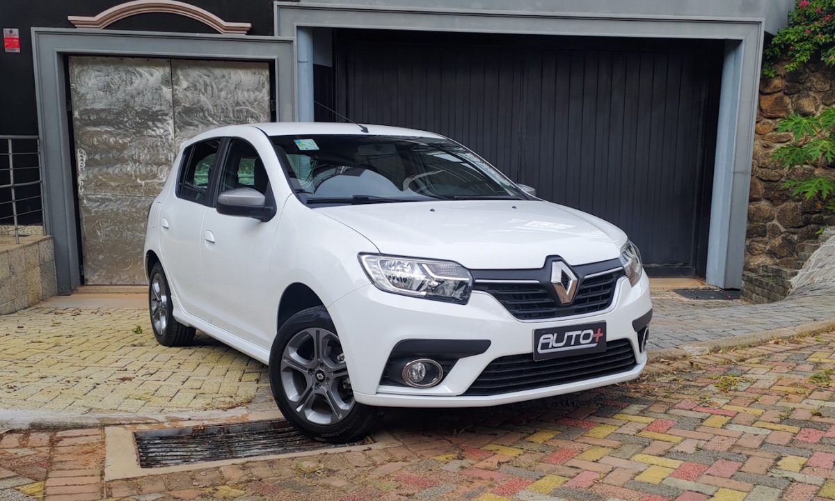 Renault Sandero GT Line branco parado de frente com portão cinza ao fundo