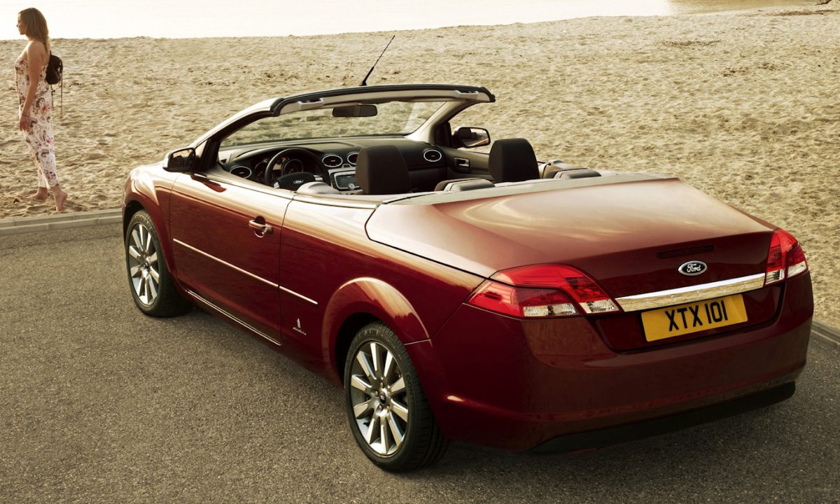 Conversível Ford Focuss CC vermelho parado de traseira com praia ao fundo