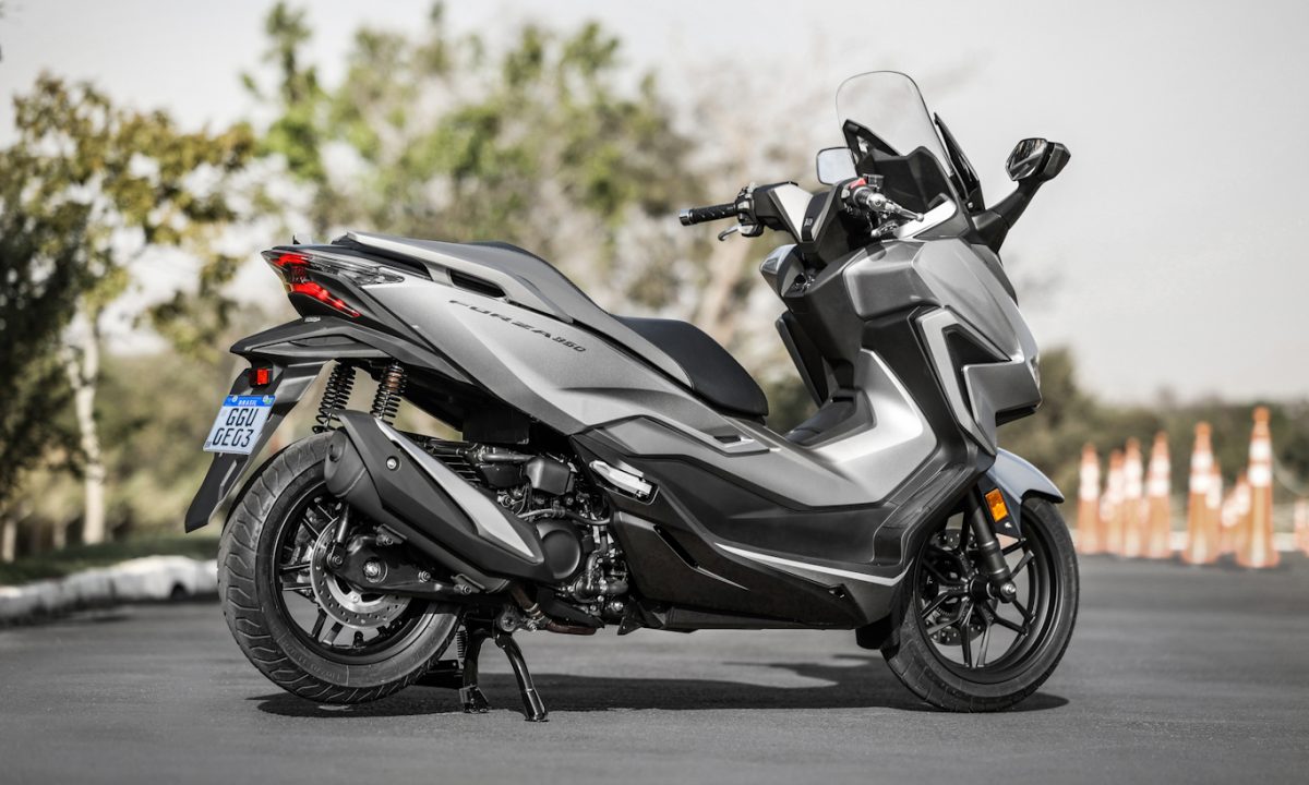 Maxi-Scooter Honda Forza 350 cinza parada de traseira no asfalto com árvores ao fundo