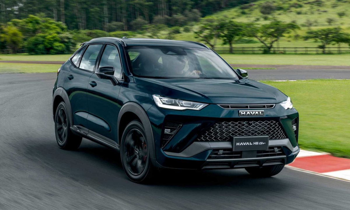 GWM Haval H6 GT de frente andando na pista com árvores ao fundo