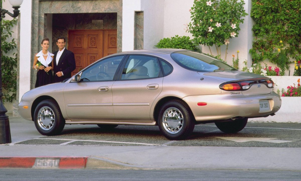 Ford Taurus de terceira geração dourado visto de lateral e traseira