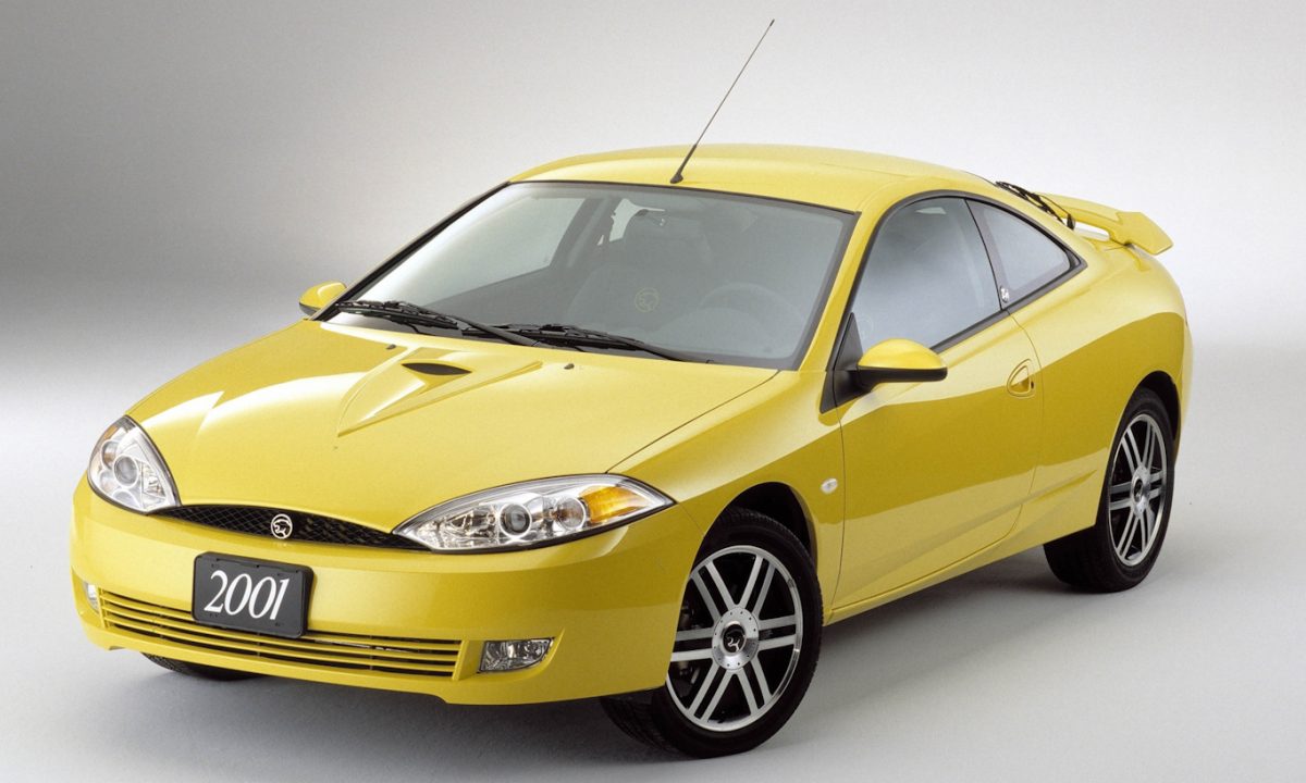 Mercury Cougar amarelo em foto 3x4 frontal estático com fundo cinza