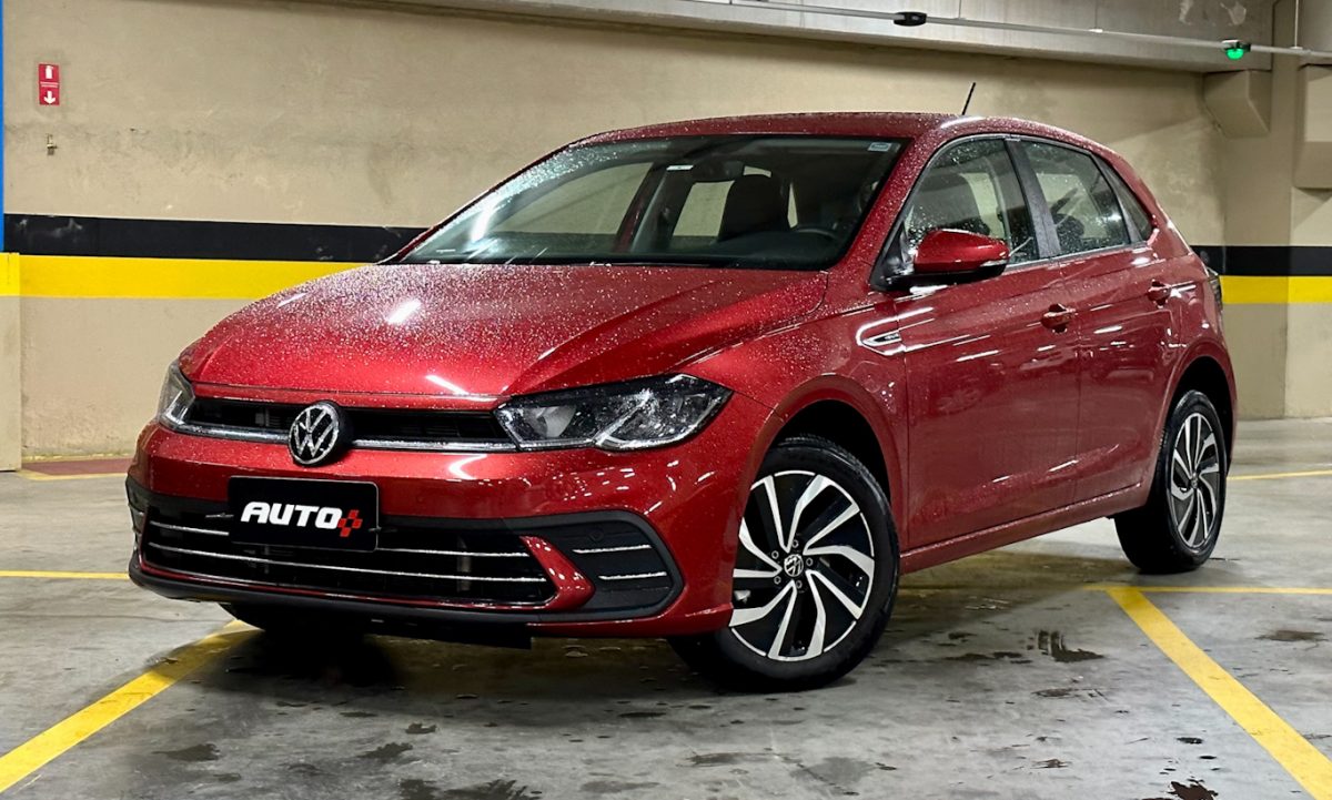 VOLKSWAGEN POLO HIGHLINE VERMELHO DE FRENTE TODO MOLHADO EM UM ESTACIONAMENTO