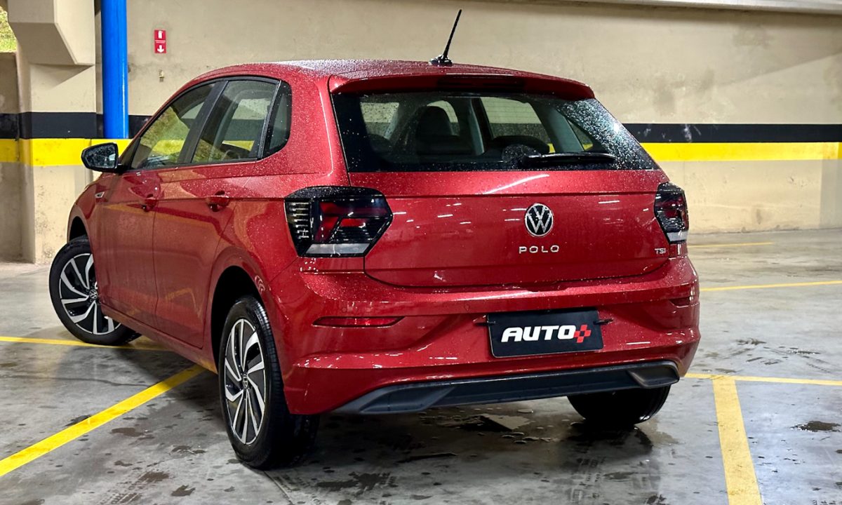 Volkswagen Polo Highline vermelho parado de traseiro no estacionamento com faixas amarelas no chão [Auto+ / João Brigato]
