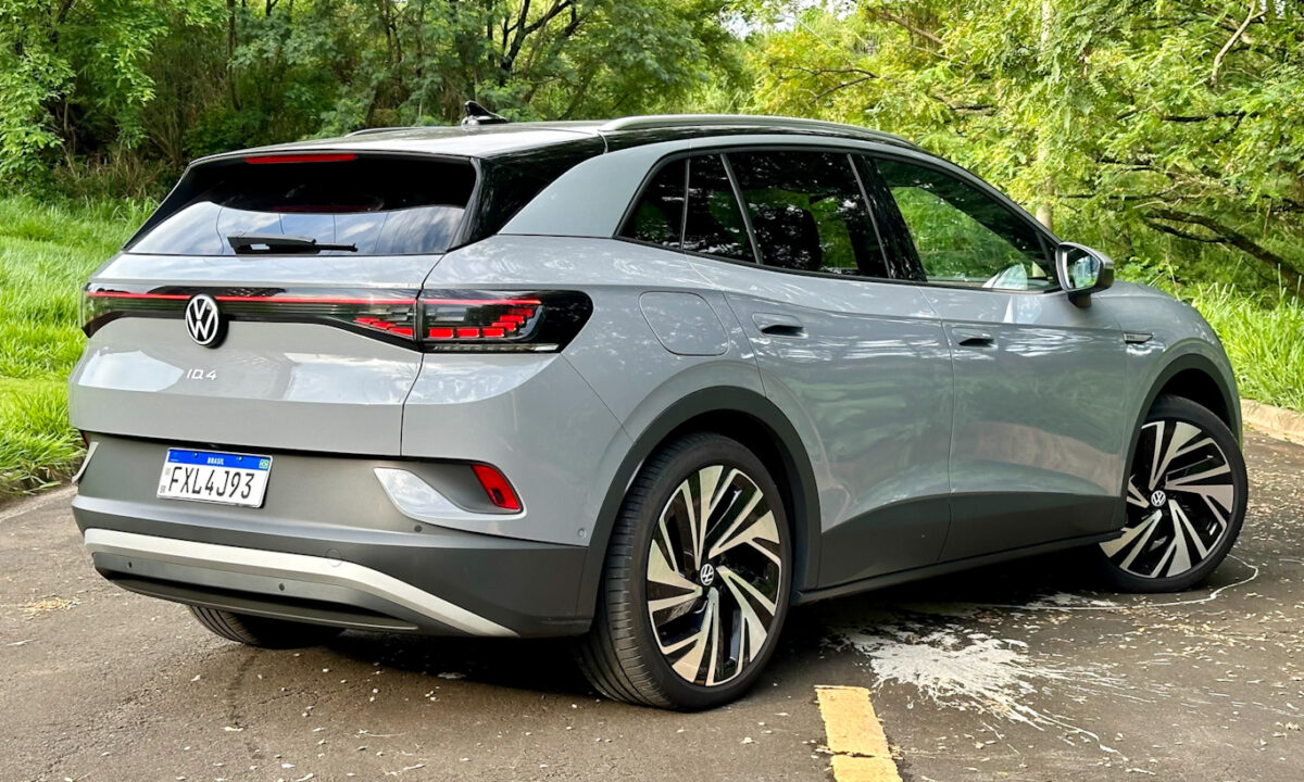 Volkswagen ID.4 cinza parado de traseira no asfalto com plantas ao fundo [Auto+ / João Brigato]