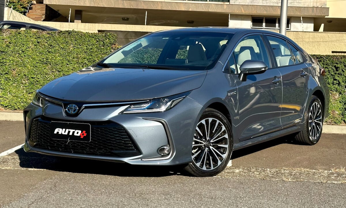 Toyota Corolla Altis Premium Hybrid  azul estacionado de frente com casa e árvores ao fundo [Auto+ / João Brigato]