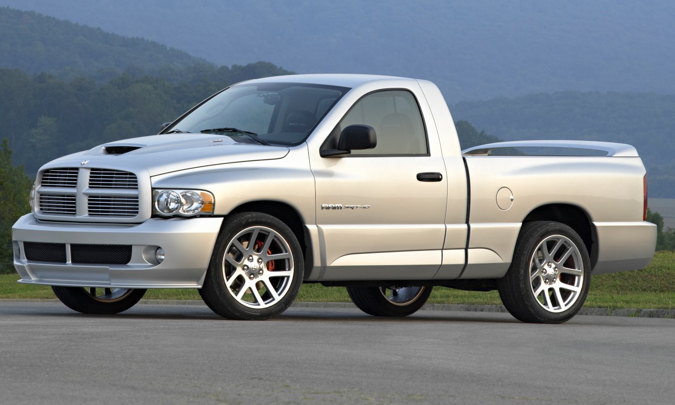 Dodge Ram SRT-10 prata parada de lateral no asfalto com montanha ao fundo