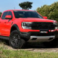 Ford Ranger Raptor laranja parada no meio de um matagal