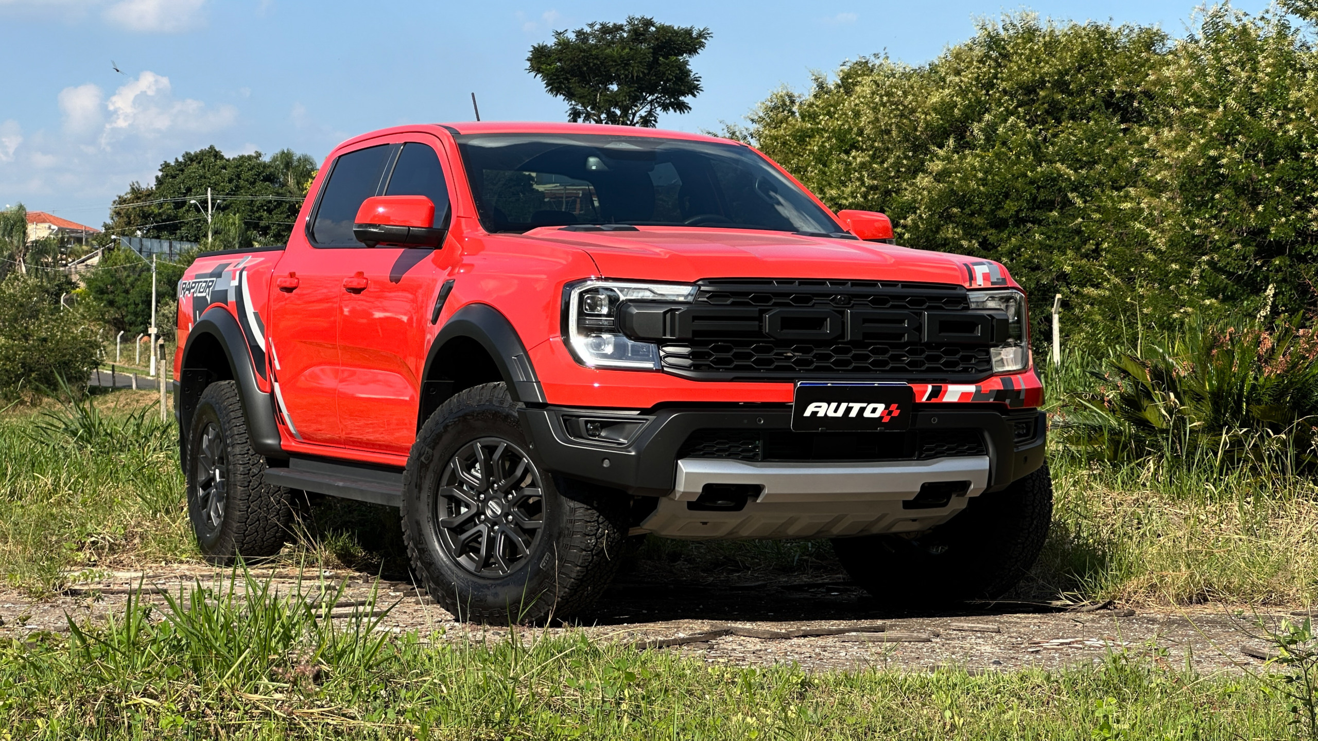 Ford Ranger Raptor laranja parada no meio de um matagal