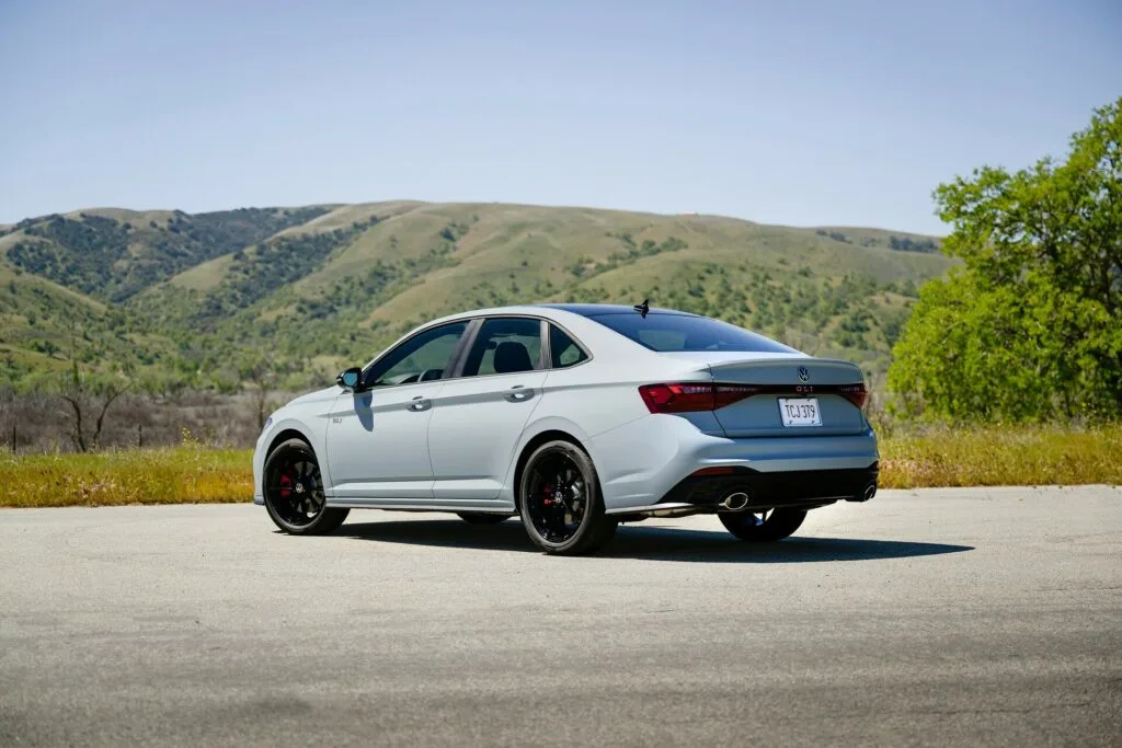 Volkswagen Jetta GLI cinza parado de traseira com montanha ao fundo