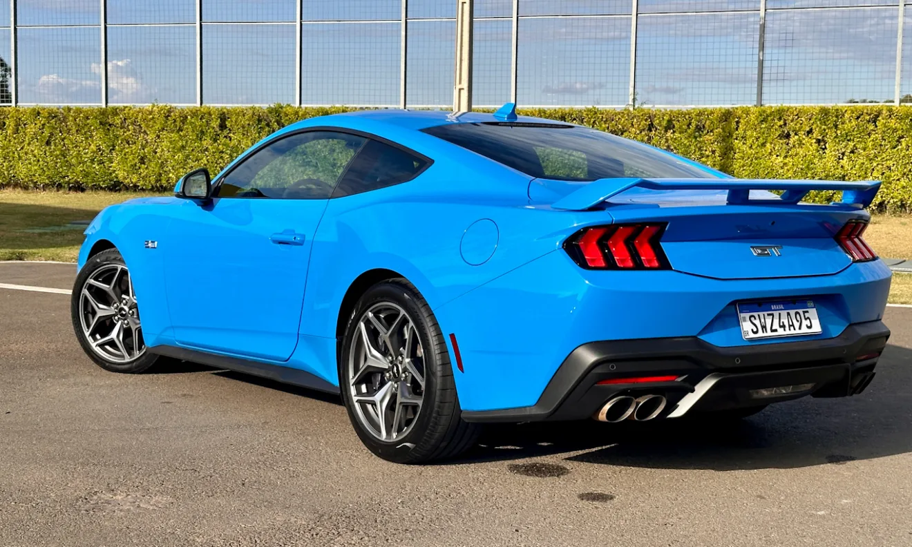 Ford Mustang GT azul de traseira em frente aos boxes do VeloCittá com muro amarelo [Auto+ / João Brigato]