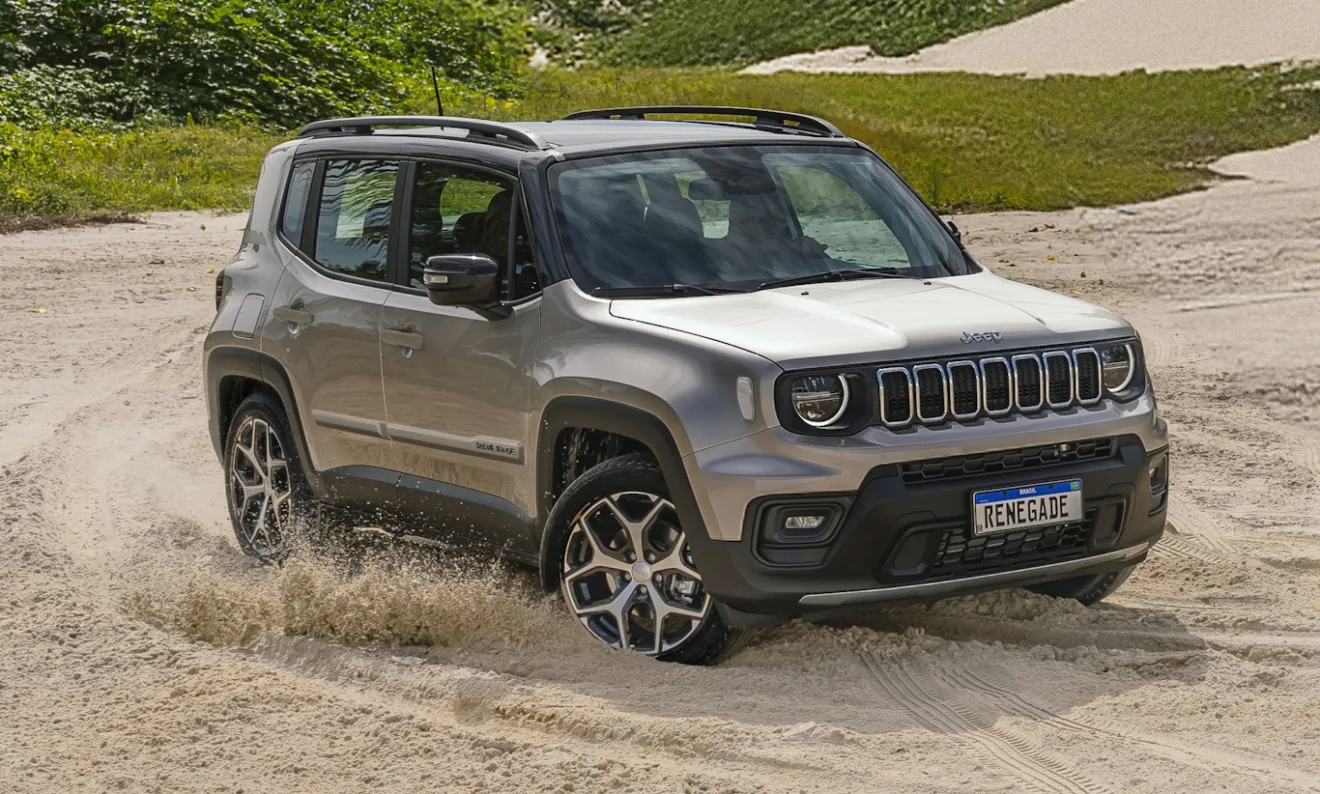 Os SUVs é um tipo de carro que não agrada a todos os consumidores, e o Jeep Renegade Sahara 2025 dourado de frente está andando na areia [divulgação]
