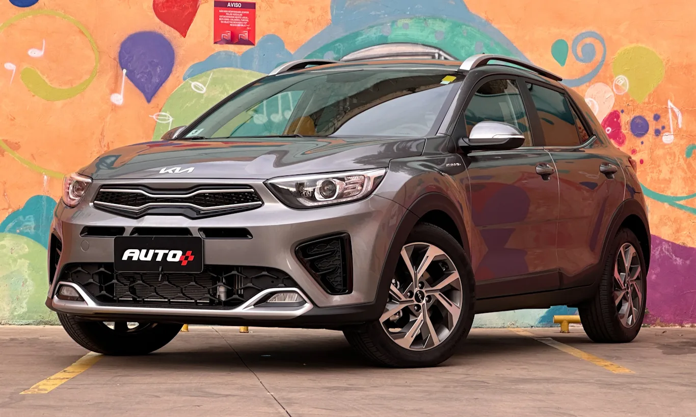 Kia Stonic prata parado em um estacionamento com um muro laranja com graffiti