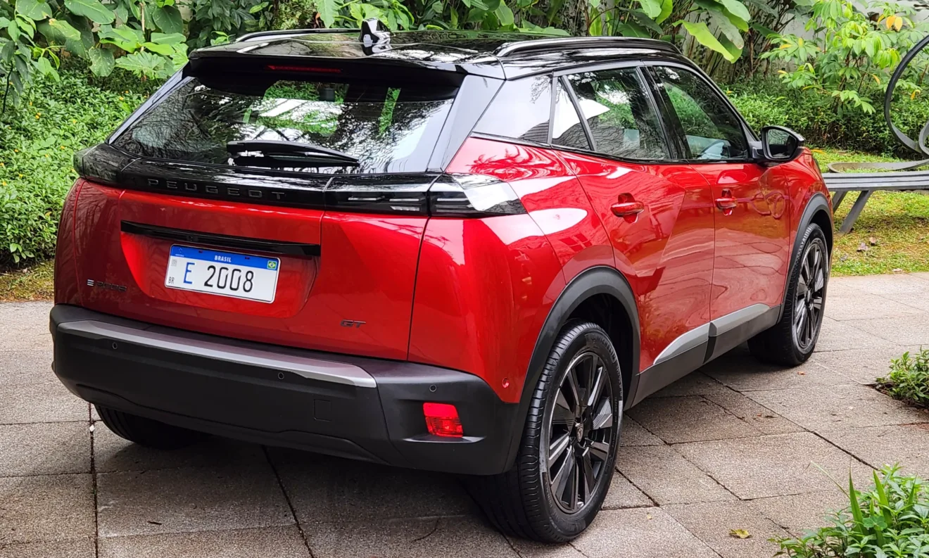 Novo 100% elétrico Peugeot e-2008 vermelho em foto estática na posição 3x4 traseiro