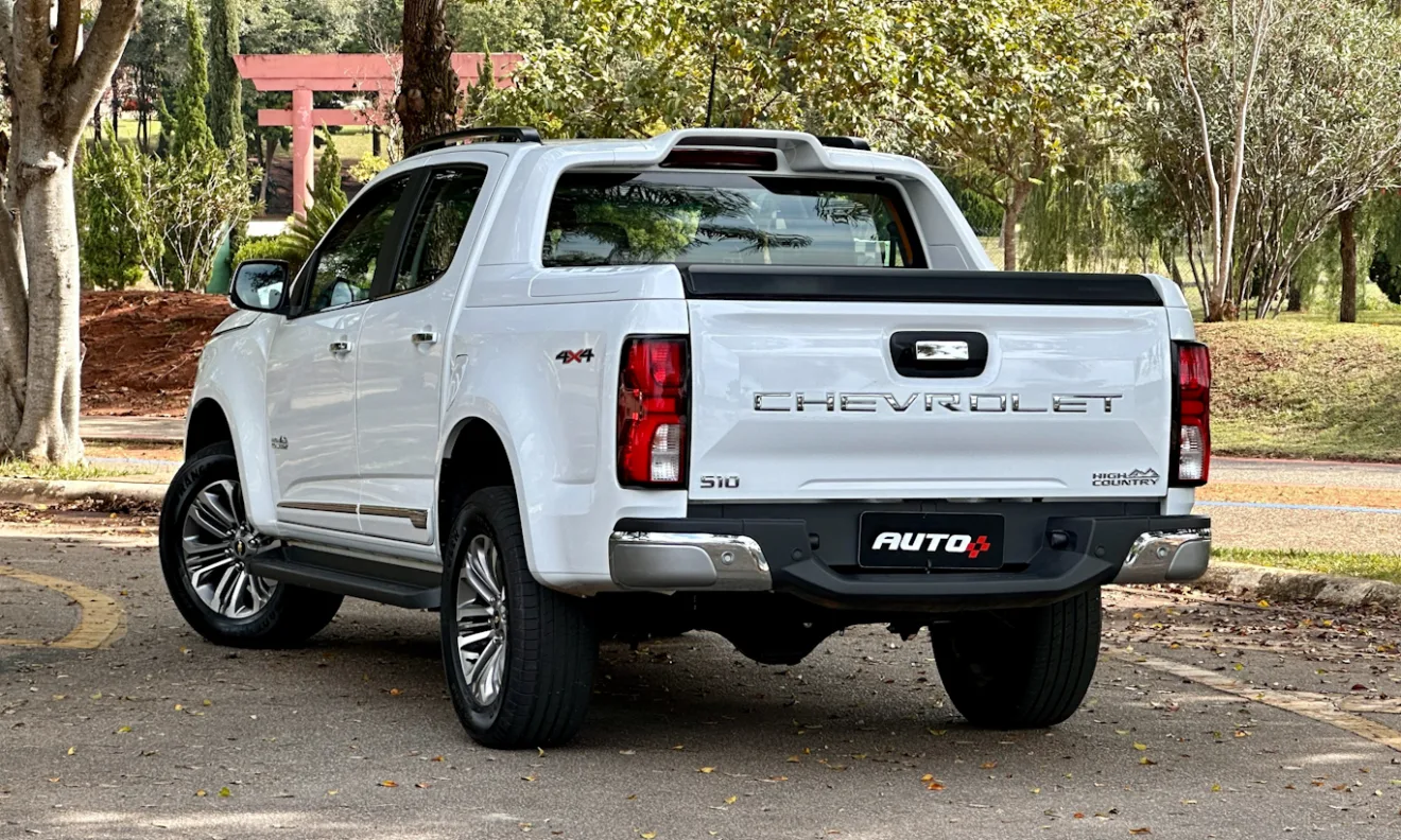 Chevrolet S10 High Country branca de traseira com árvores ao fundo