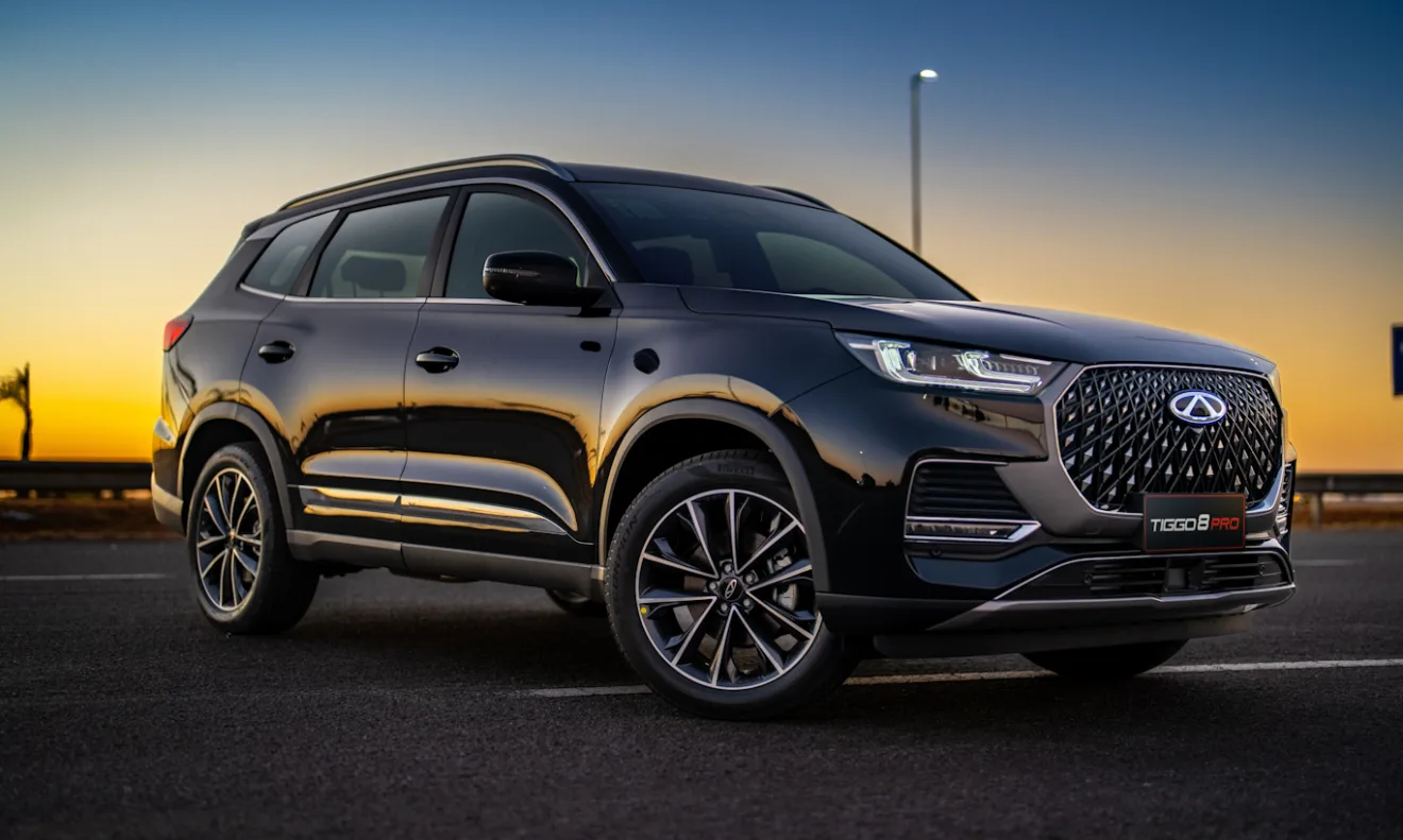 CAOA Chery Tiggo 8 Pro preto de frente com rodas escuras em um por do sol