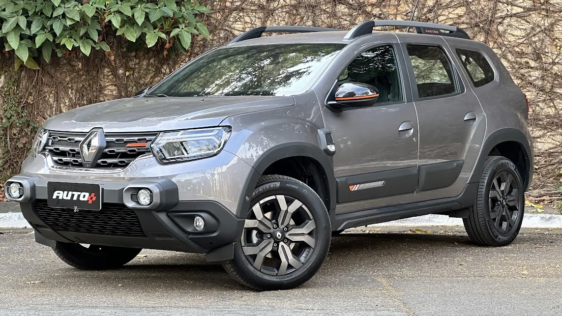 renault duster cinza de frente com um muro de pedras atrás