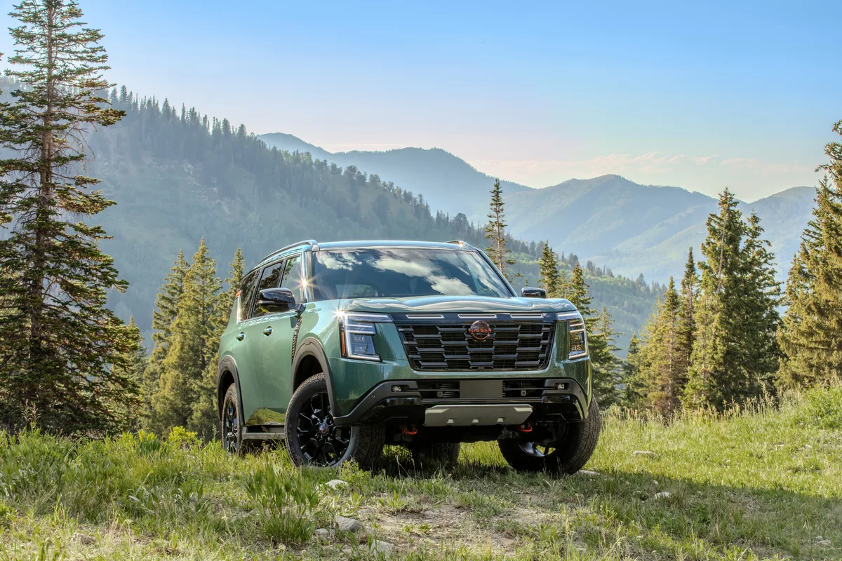 Nissan Armada Pro-4X verde parado no off-road com montanhas e árvores ao fundo