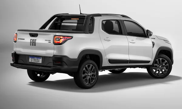 Fiat Strada Tributo 125 branca com rodas escuras parada de traseira