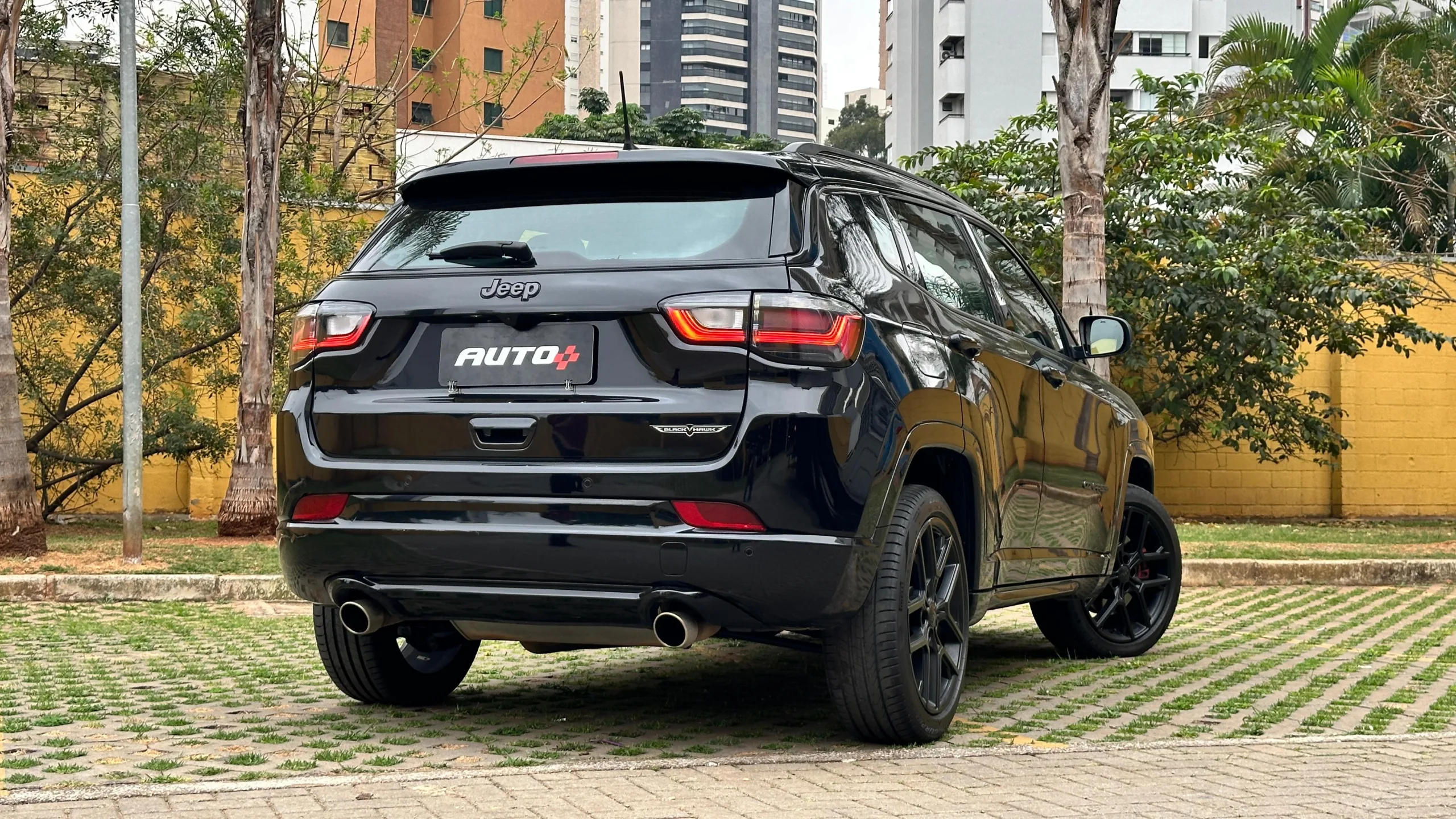 Jeep Compass Blackhawk preto estacionado de traseira na grama