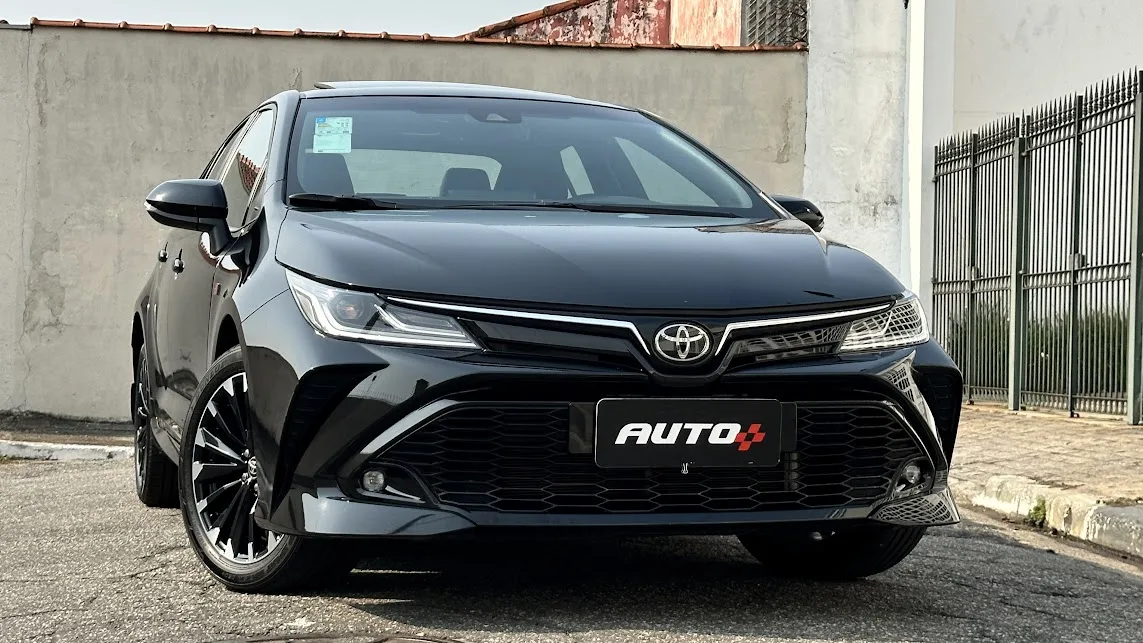 Toyota Corolla GR-Sport preto estacionado de frente no asfalto com muro ao fundo