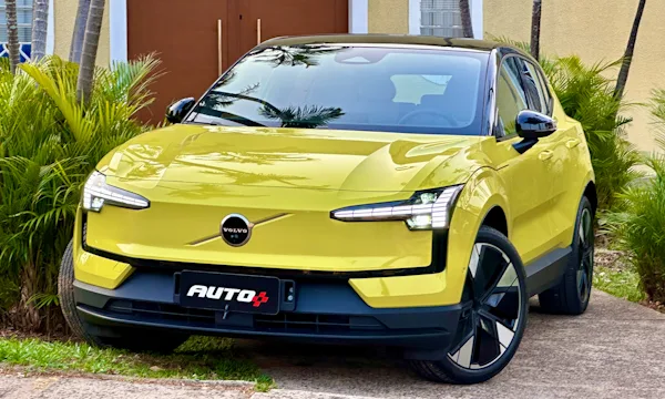 frente do Volvo EX30 Ultra amarelo com teto preto com faróis acesos