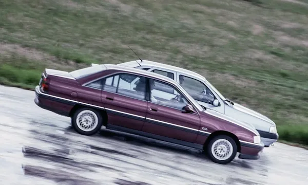 Chevrolet Omega bordô ao lado de um Fiat Tempra prata parcialmente coberto pelo sedã da Chevrolet