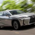 Novo Lexus UX 300h prata visto de frente com fundo de folhas