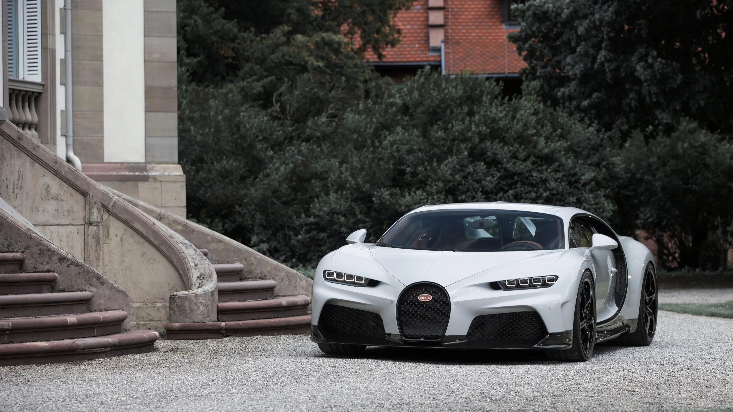 Bugatti Chiron Pur Sport branco em foto estática em frente a uma escadaria com plantas ao fundo