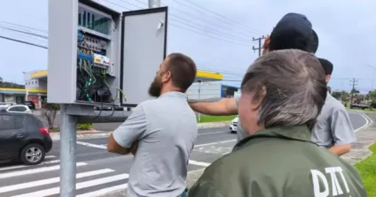 Central semafórica sendo testada e técnicos avaliando o funcionamento com avenida ao fundo