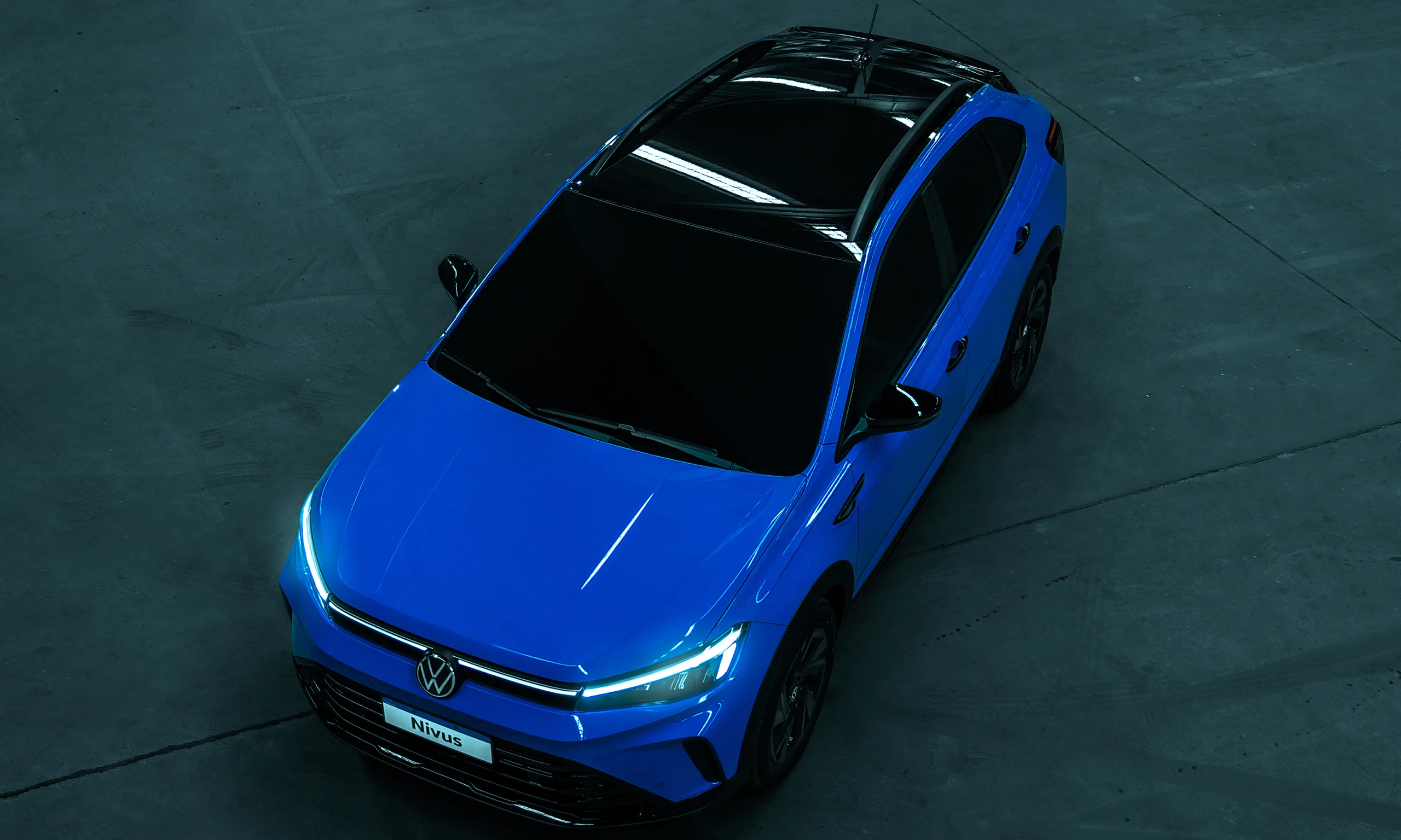 Visão aérea do novo Volkswagen Nivus Highline azul com fundo cinza