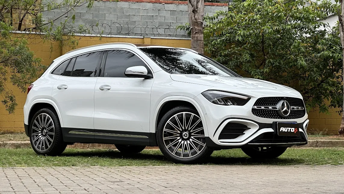 Mercedes-Benz GLA 200 AMG Line branco em foto de frente com muro amarelo e plantas ao fundo