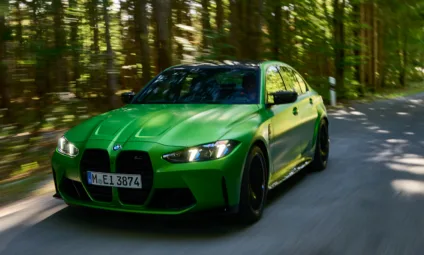 Novo BMW M3 Competition Track verde em foto 3x4 frontal na estrada