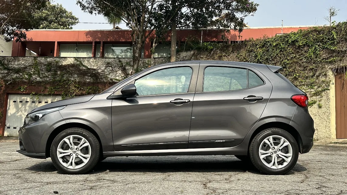Fiat Argo cinza parado de lateral com casa ao fundo