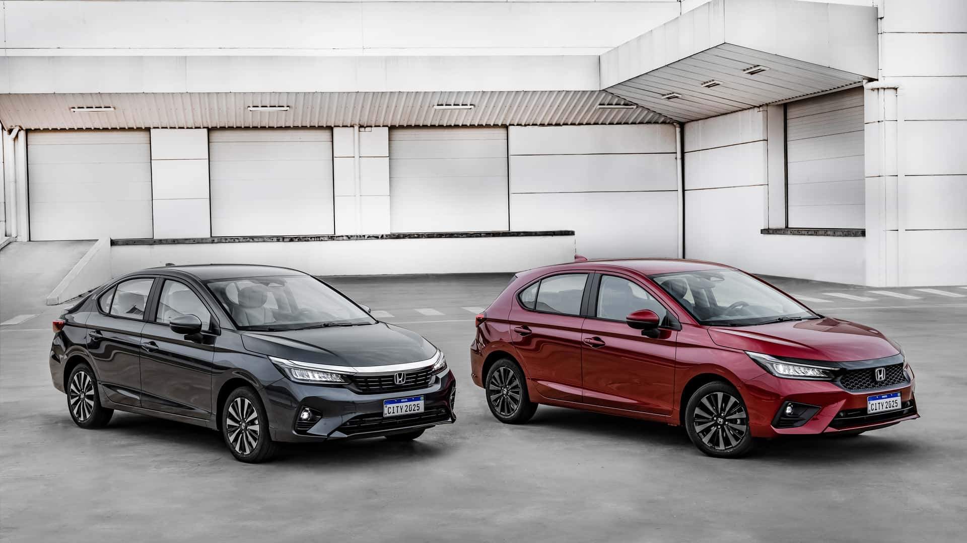 Novos Honda New City 2025 sedã cinza e hatch veremlho com fundo claro