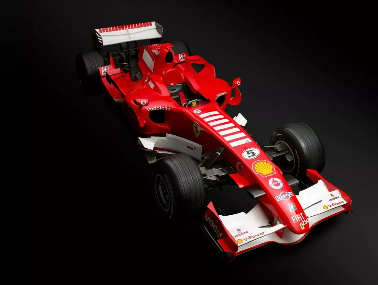 Ferrari 248 F1 vermelha de Michael Schumacher em foto do alto com chão e fundo preto