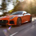 Jaguar F-Type Coupé SVR laranja em 3x4 frontal na estrada