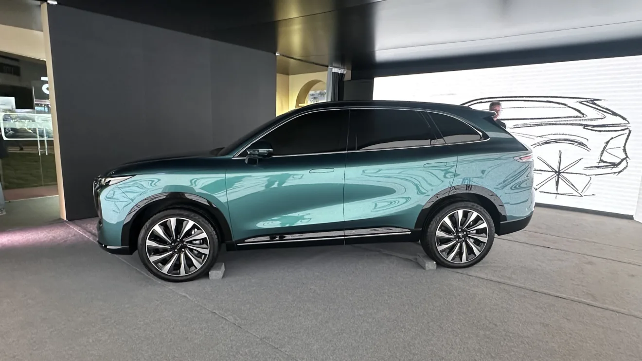 Chery Lepas 8 verde de frente em um fundo com desenhos do SUV que parece um Porsche Cayenne