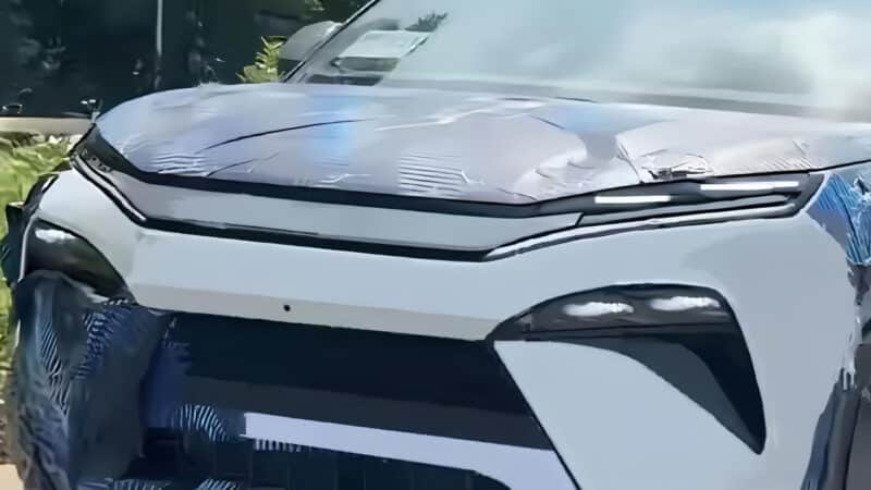 Parte sem camuflagem do novo SUV BYD Tang L na frente, pintado de branco com camuflagem azul