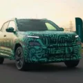 Novo SUV Skoda Kylaq visto de frente, andando em uma pista e com camuflagem esverdeada