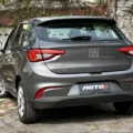 Fiat Argo cinza parado de traseira em frente a um portão
