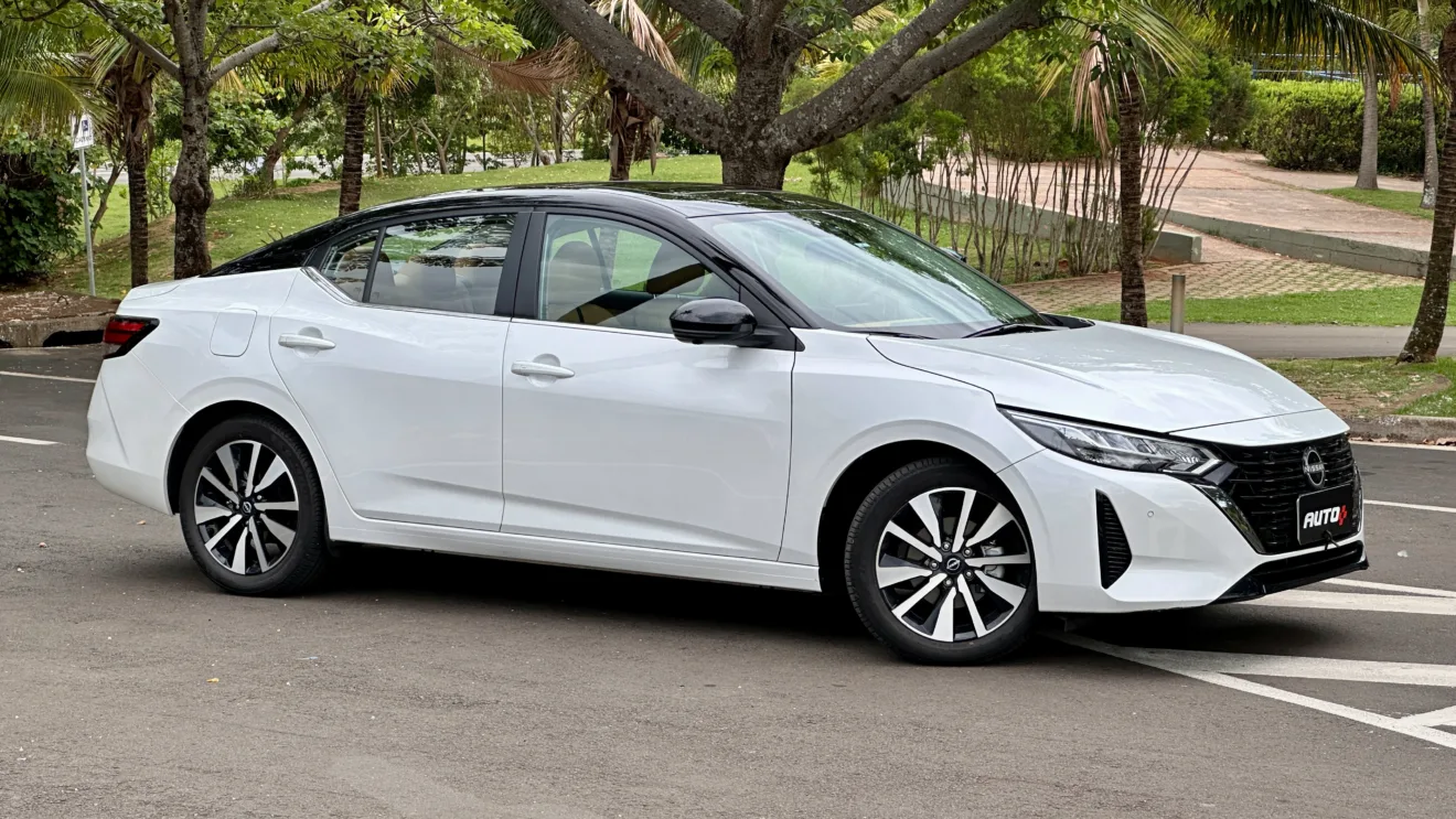 Nissan sentra exclusive branco com teto preto parado em frente árvores bem grandes