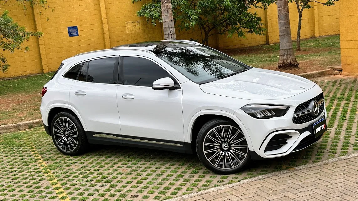 Mercedes-Benz GLA 200 AMG Line branco visto do alco com muro amarelo e plantas ao fundo