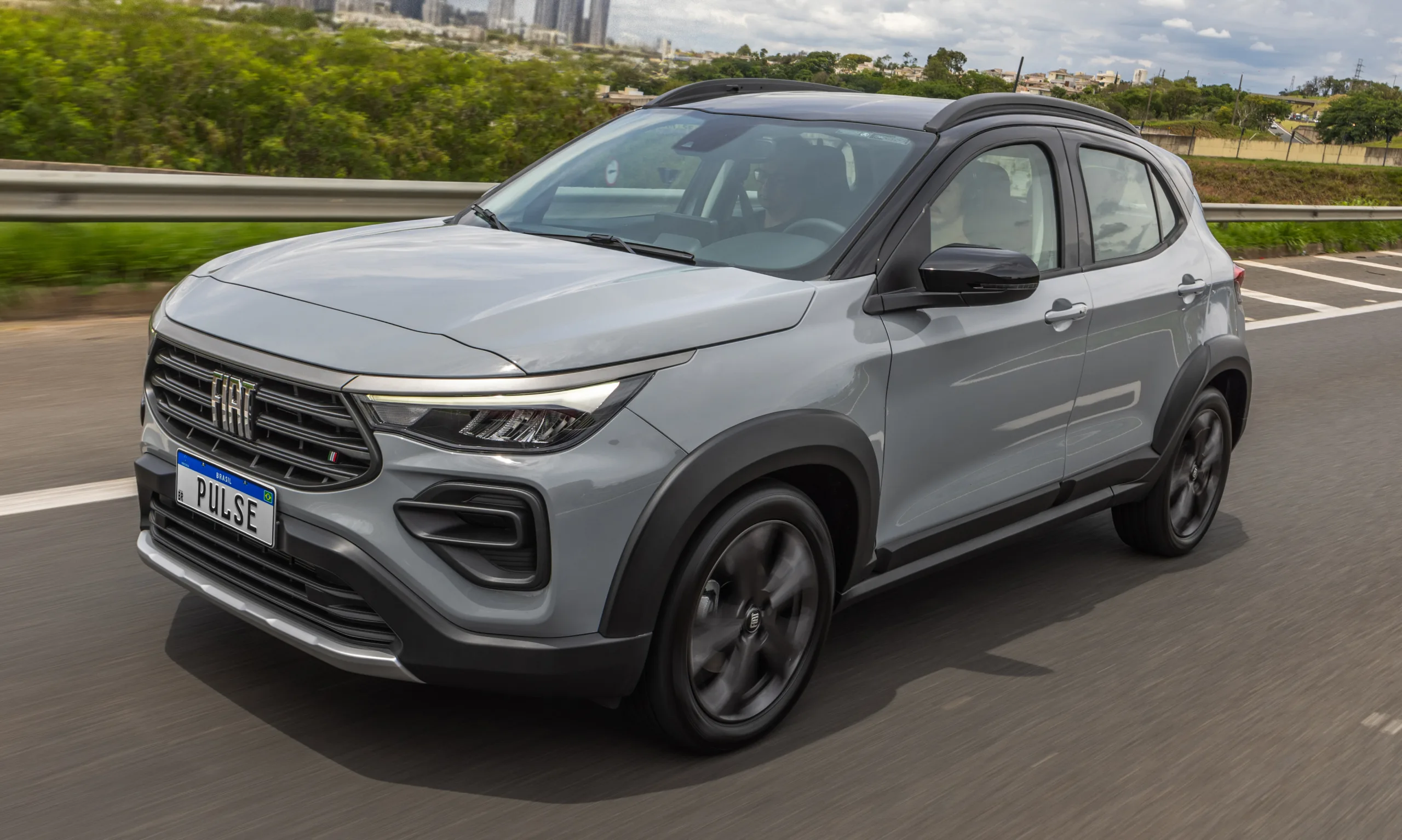 Fiat Pulse Audace T200 Hybrid cinza com teto preto, visto de frente andando em estrada