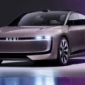 Dianteira do novo AUDI E Concept cinza claro, com faróis acesos e fundo escurecido